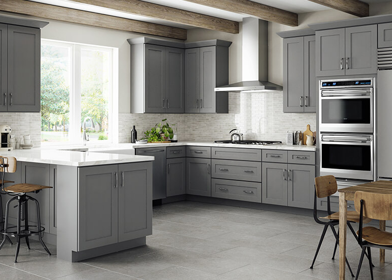 A kitchen with grey cabinets and white countertops.